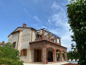 una antigua casa de piedra con techo en Paradise Villa Cassonni Istria 4 Stars, en Butkovići