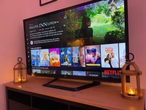 a flat screen tv sitting on a table with two candles at Mille et une nuit, appartement classé 3 étoiles en RDC avec exterieur et parking in Dole
