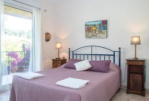 una camera con letto viola e 2 cuscini di Mas Catalan avec piscine 12 à 15 personnes ad Argelès-sur-Mer Altre 14 foto