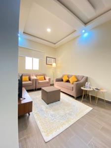 ein Wohnzimmer mit 2 Sofas und einem Teppich in der Unterkunft الأراضي السبع in Yanbu