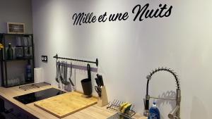 a kitchen with a counter with a knife and wire muffins sign at Mille et une nuit, appartement classé 3 étoiles en RDC avec exterieur et parking in Dole