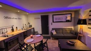 a living room with a couch and a table with chairs at Mille et une nuit, appartement classé 3 étoiles en RDC avec exterieur et parking in Dole