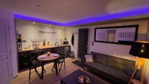 a living room with a couch and a table at Mille et une nuit, appartement classé 3 étoiles en RDC avec exterieur et parking in Dole