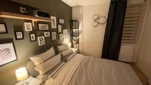 a bedroom with a bed with pictures on the wall at Mille et une nuit, appartement classé 3 étoiles en RDC avec exterieur et parking in Dole