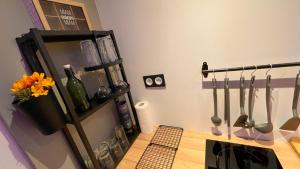 a kitchen with a counter with utensils on a wall at Mille et une nuit, appartement classé 3 étoiles en RDC avec exterieur et parking in Dole