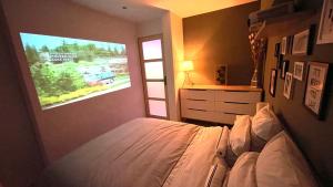 a bedroom with a bed and a tv on the wall at Mille et une nuit, appartement classé 3 étoiles en RDC avec exterieur et parking in Dole