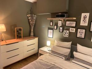 a bedroom with a bed and a dresser and pictures on the wall at Mille et une nuit, appartement classé 3 étoiles en RDC avec exterieur et parking in Dole