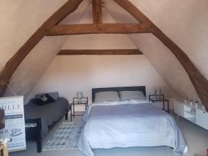ein Schlafzimmer mit einem Bett im Dachgeschoss in der Unterkunft LA PAGODE in Osmoy-Saint-Valery