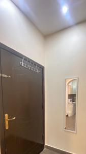 Zimmer mit einer schwarzen Tür und einem Spiegel in der Unterkunft الأراضي السبع in Yanbu