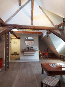 een zolderkamer met houten vloeren en een tafel bij Butterfly in Brugge