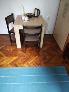 een tafel met 2 stoelen en een tafel en stoelen bij Random Room in Zagreb
