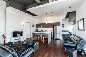 an open living room with leather furniture and a kitchen at 1BR Furnished Apartment in Hollywood - Walk of Fame apts in Los Angeles