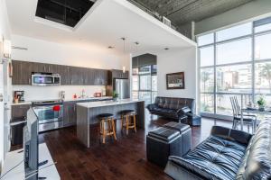an open kitchen and living room with leather furniture at 1BR Furnished Apartment in Hollywood - Walk of Fame apts in Los Angeles