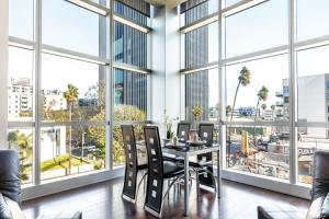 d'un bureau avec une table, des chaises et de grandes fenêtres. dans l'établissement 1BR Furnished Apartment in Hollywood - Walk of Fame apts, à Los Angeles