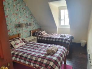 a bedroom with two beds with a teddy bear on the bed at Argyll Mansions Penthouse in Oban