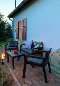 une terrasse avec un canapé et une table avec une bougie dans l'établissement Tiszai Fenyves Apartman, à Tiszadorogma