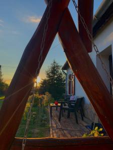 Blick auf eine Terrasse mit einem Tisch und einer Bank in der Unterkunft Tiszai Fenyves Apartman in Tiszadorogma