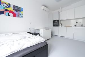 um quarto branco com uma cama e uma cozinha em A&D Studios em Zagreb