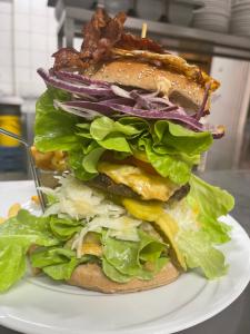 a large sandwich with lettuce and bacon on a plate at Landgasthof Zum Alten Reichenbach in Nesselwang