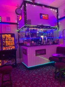 a bar in a restaurant with purple lights at The Croydon in Blackpool