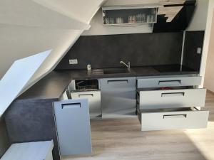 eine Küche mit Geräten aus Edelstahl und eine Treppe in der Unterkunft La Marina in Saint-Jean-de-Losne + 4 Fotos