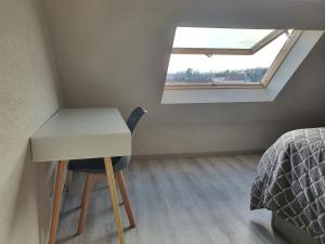 ein Zimmer mit einem Schreibtisch und einem Bett und einem Fenster in der Unterkunft La Marina in Saint-Jean-de-Losne