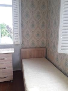 ein kleines Schlafzimmer mit einem Bett und einem Fenster in der Unterkunft liziko's House in Kobuleti