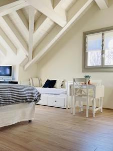 een slaapkamer met een bed, een bureau en een tafel bij Loft Naturalpina Dolomiti Farm in Belluno