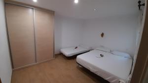 a small room with two beds and a closet at Rosesapparts Voramar - La Cuana in Roses