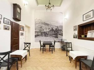 a room with a table and chairs and a painting on the wall at A10 Budapest Center Aparthotel in Budapest