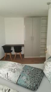 a bedroom with a bed with a desk and a dresser at Schickes Ferienappartement in Lochau