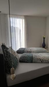 1 cama con almohadas y ventana en Schickes Ferienappartement, en Lochau