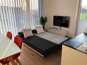 Habitación pequeña con cama y TV. en Schickes Ferienappartement, en Lochau