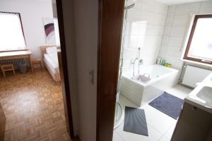 a bathroom with a bath tub and a sink at Familienzimmer in Neumarkt in der Oberpfalz