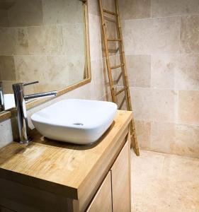ein Badezimmer mit einem weißen Waschbecken auf der Theke in der Unterkunft Belle maison provençale au pied du Mont Ventoux in Caromb