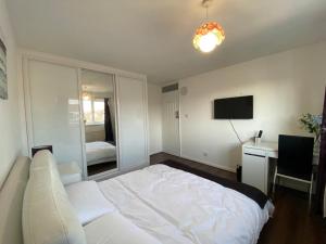 a bedroom with a bed and a desk and a television at Lovely Homes in Aylesbury