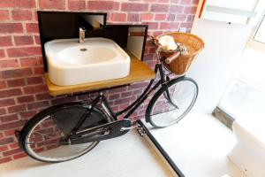 una bicicletta parcheggiata contro un muro di mattoni con lavandino di Stunning & unique apt in Culross a Culross