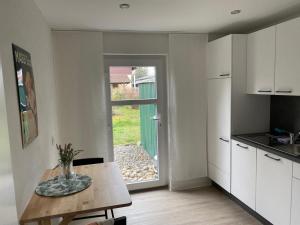 uma cozinha com uma mesa e uma porta para um quintal em Rheingold em Kehl am Rhein