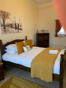 a bedroom with a large white bed with yellow pillows at Home with a view in Moffat