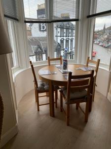 einen Tisch und Stühle in einem Zimmer mit einem großen Fenster in der Unterkunft Home with a view in Moffat