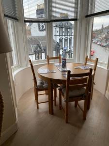 a table and chairs in a room with a large window at Home with a view in Moffat