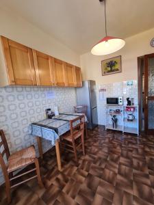 kuchnia ze stołem, krzesłami i lodówką w obiekcie Casa dell amore 3 w San Remo