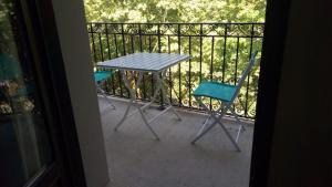 une table et deux chaises assises sur un balcon dans l'établissement T2 Calme assuré face à la pique les Ramel, à Luchon