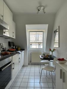 a kitchen with white cabinets and a table and chairs at Travemünde Ferienwohnung am Meer in Travemünde