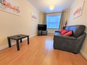 a living room with a couch and a table at Friars Walk 2 with 2 bedrooms, 2 bathrooms, fast Wi-Fi and private parking in Sittingbourne
