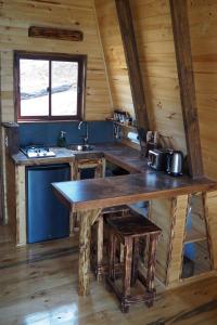 a kitchen with a wooden table in a cabin at Cabañas einklang in Lolol