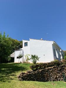 una casa blanca con una pared de piedra delante de ella en chalet con vistas a sevilla, en Gelves