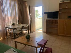 a living room with a table and a dining room at Playa Troya Apartment at the beach in Playa de las Americas