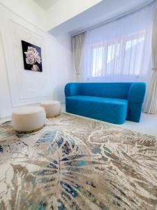 - un salon avec un canapé bleu et un tapis dans l'établissement Unique Hotel Apartments Iasi, à Iaşi