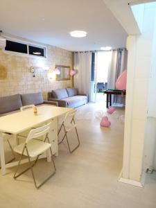 Una sala de estar con una mesa y sillas y un sofá. en כוכב הים וילה מול הגלים וברכה פרטית סגורה, en Netanya